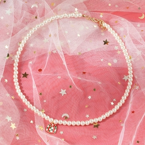 Detailed view of pearl necklace with a festive red Christmas gift box pendant charm