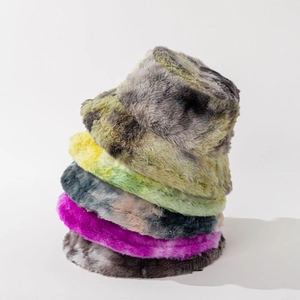 Close-up of stacked colorful tie-dye faux fur bucket hats with thick winter texture