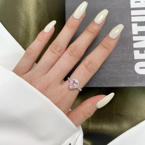 Detail of s925 silver ring with pear-shaped pink diamond and halo design on hand