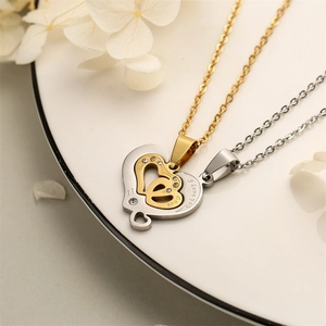 Detail shot of heart-shaped music note couple pendants with I love you engraving