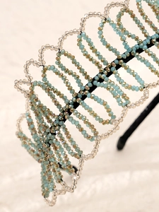 Close-up of handmade ethnic headband with blue crystal beads and intricate floral weave