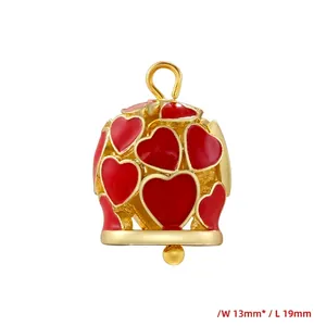 Detail view of red enamel heart bell pendant with gold frame measuring 13mm by 19mm