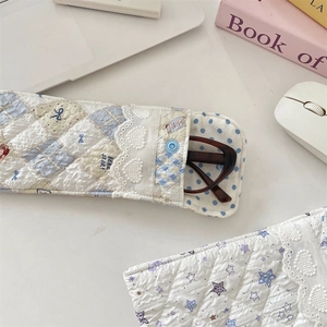 Close-up of quilted cotton glasses pouch with star texture and delicate lace trim