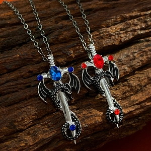 Macro view of dragon pendants with blue and red faceted stones on dark wood
