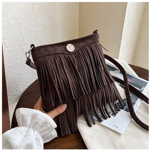 Detailed view of a dark brown suede tassel crossbody bag with silver round hardware