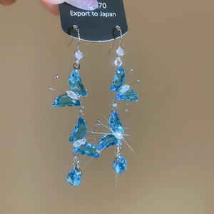 Macro view of blue butterfly drop earrings with cubic zirconia and sparkling star light effect