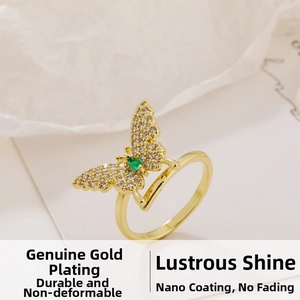 Detail of gold butterfly ring with micro-set white zircon and green marquise stone