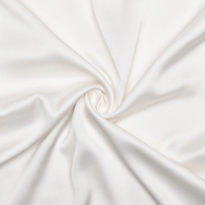 Vue détaillée de la texture élégante du satin blanc et du drapé fluide de la robe à fleurs