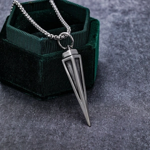 Vintage stainless steel triangle cone pendant necklace displayed on green velvet jewelry box