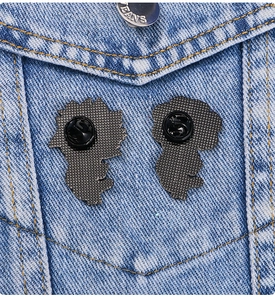 Detail of metal enamel pin backs with black rubber clutches on blue denim jacket