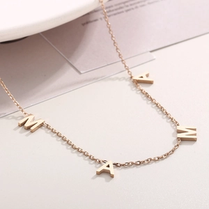 Macro view of MAMA letter pendant in rose gold finish with delicate metal chain
