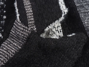 Close-up of black and white vertical stripe boucle fabric showing woolly knit texture