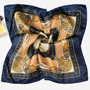 Close-up of luxury square silk scarf with baroque chain prints and satin finish