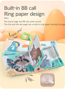 Detail of soft baby cloth book with animal prints, squeaker and green hanging ring