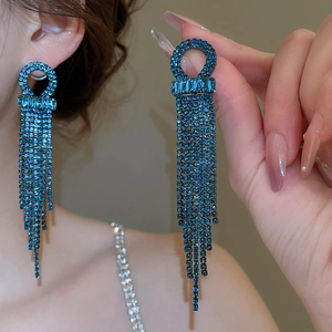 Close-up of blue rhinestone tassel earrings showing high-shine crystals on model