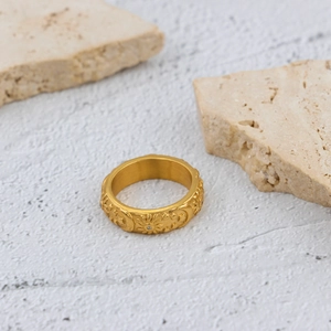 Detailed view of vintage gold ring with celestial sun, moon, star relief and zircon