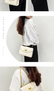 Detail showing white quilted crossbody bag with golden chain strap and decorative buckle