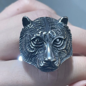 Macro shot of a vintage stainless steel tiger head ring with realistic embossed details