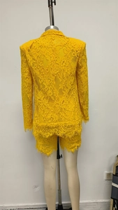 Vista posteriore del set blazer in pizzo giallo e pantaloncini con orlo in pizzo