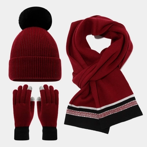 Detail view of burgundy winter knit set with touch-screen gloves and faux fur pom pom hat