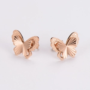 Detailed close-up of rose gold butterfly stud earrings with hollow wings and textures