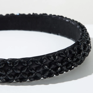 Close-up of black beaded headband showing woven crystal beads and satin texture details