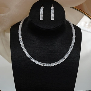 Close-up of sparkling cubic zirconia necklace and long dangle earrings on black display