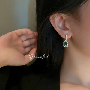 Elegant geometric gold earrings with green emerald-cut stones and halo crystal accents