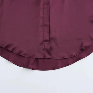 Detail of the curved hemline and fine stitching on a premium purple satin blouse