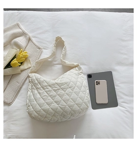 Detailed close-up of a cream white quilted nylon tote bag with soft padding and texture