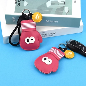 Pink PU leather boxing glove keychain with yellow come on tag on blue background