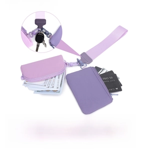 Portable purple wristlet wallet set for keys, cards, lipstick, and coins on white background