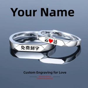 Detail of silver couple rings with geometric facets and custom engraving surface
