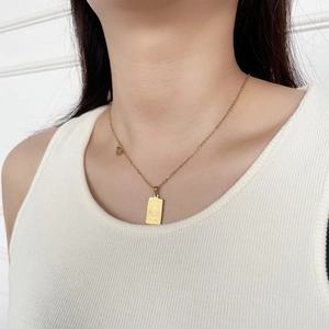 Golden stainless steel Leo tarot card necklace with rectangular pendant on a model