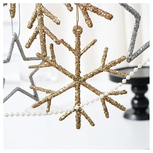 Macro shot of sparkling gold snowflake and silver star Christmas ornaments with glitter