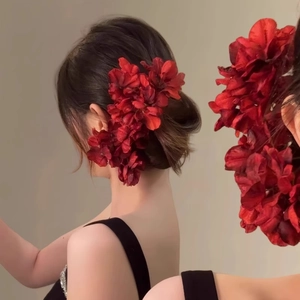 Épingle à cheveux élégante avec fleurs en tissu rouge foncé sur un chignon vintage