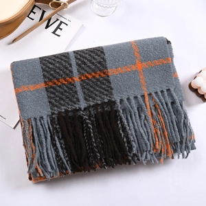 Detail of grey plaid cashmere scarf showing soft fringe and textured yarn fabric