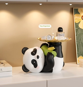 Cute panda resin sculpture with golden metal tray holding watch, perfume and keys