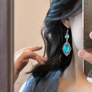 Detail shot of vintage silver earrings with blue resin stones worn in a mirror selfie
