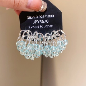 Detailed macro view of 925 sterling silver hoop earrings with blue crystal beads