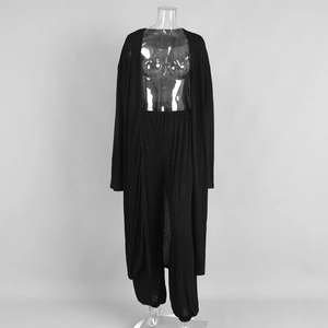 Detail of black semi-transparent knit long cardigan and matching wide-leg trousers set