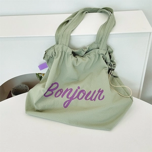 Macro detail of light green waffle fabric texture with purple Bonjour print and drawstring