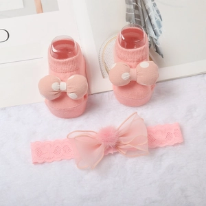 Set fascia e calzini neonato rosa con fiocchi di pizzo e pois su sfondo di peluche