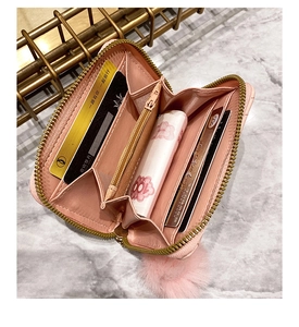 Pink zip-around accordion wallet interior showing card slots and pompom charm