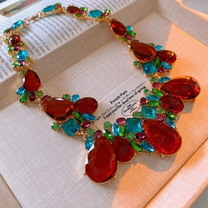 Macro detail of vintage teardrop pendant necklace with colorful crystals and gold finish