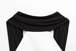 Detail of the high-contrast black and white patchwork neckline with pleated design