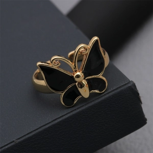 Macro shot of gold butterfly ring with black enamel wings on a jewelry box edge