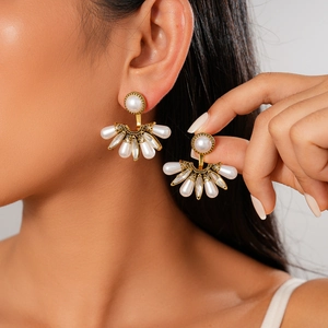 Gros plan de boucles d'oreilles baroques en éventail avec perles et cristaux