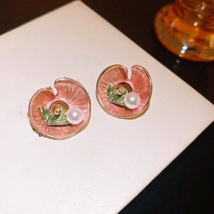 Macro detail of pink enamel lotus leaf earrings with gold veins and white pearls