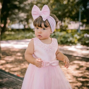 Detail of baby girl pink tulle dress with satin bodice, pearl collar and matching headband